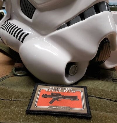 Stormtrooper helmet alongside patch displaying blaster