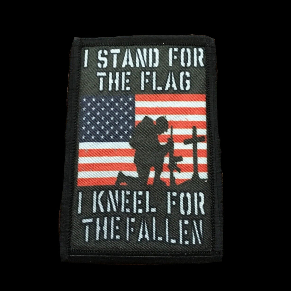 I stand for the Flag and Kneel for the Fallen Patriotic Morale Patch. Hook and loop backing with a soldier kneeling in front of a cross with the USA flag behind it.