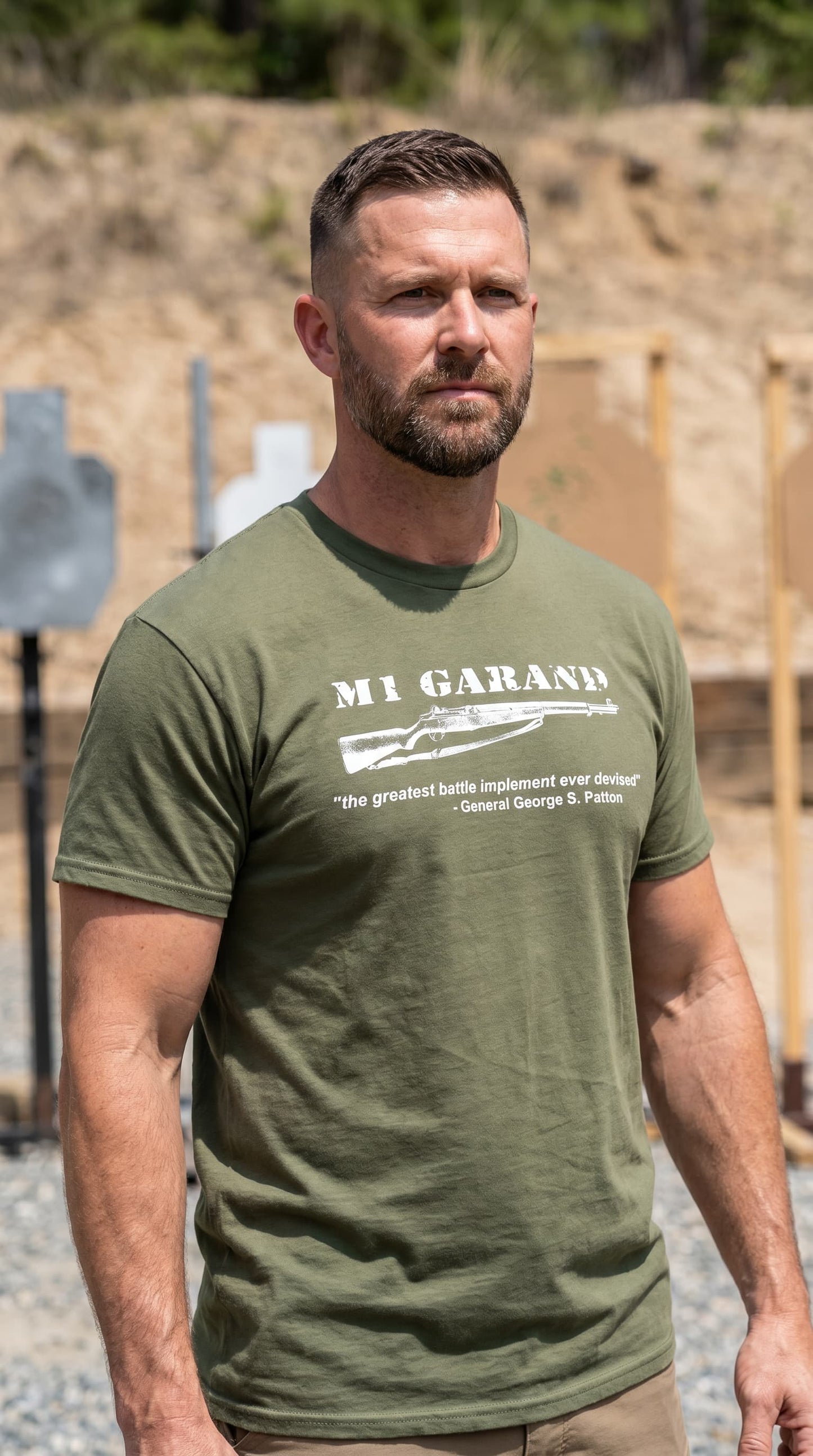 A man wearing an olive green t-shirt featuring an M1 Garand and a quote form General Patton 