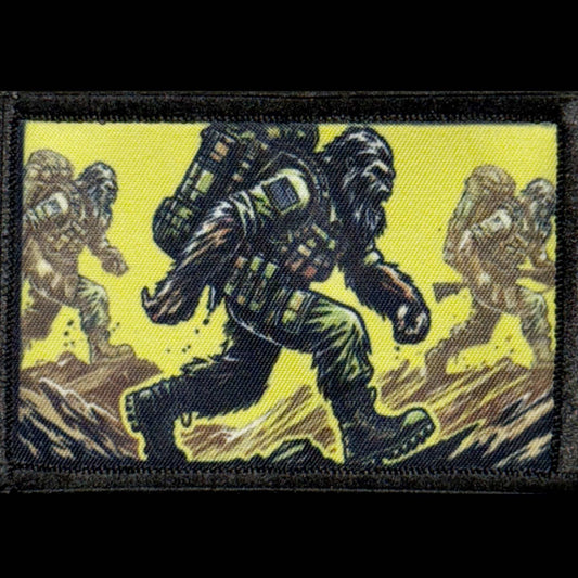 Sasquatch Ruck morale patch showing a tactical Bigfoot carrying a loaded backpack across rocky terrain